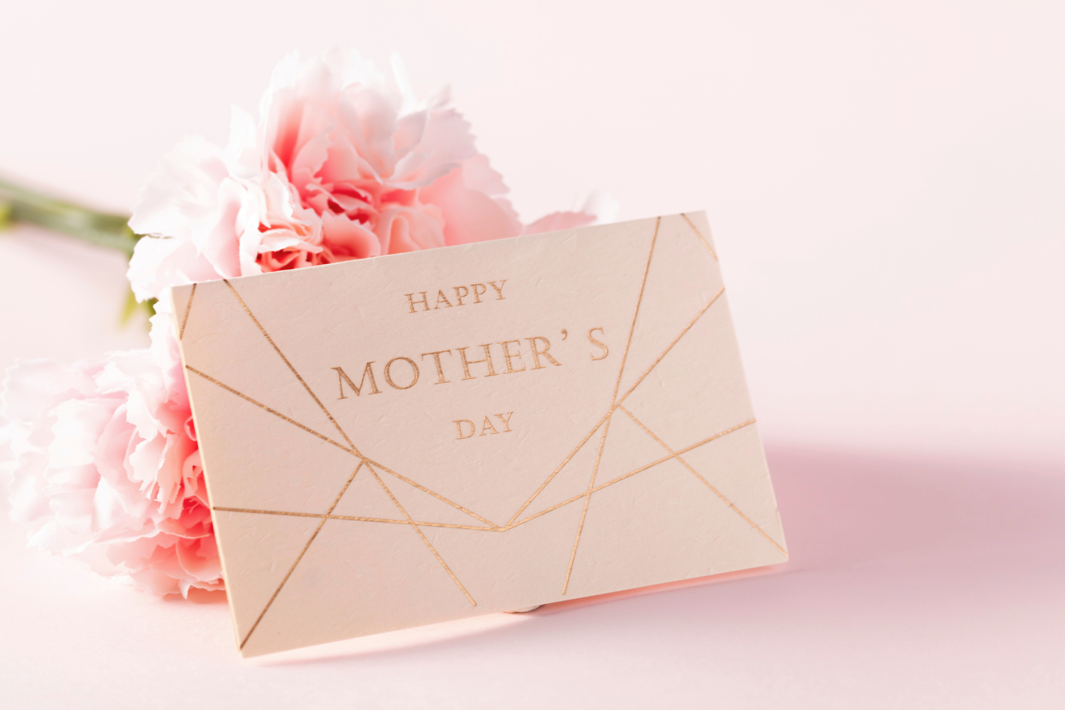 Happy Mother's Day card with inspirational quote beside a bouquet of flowers.