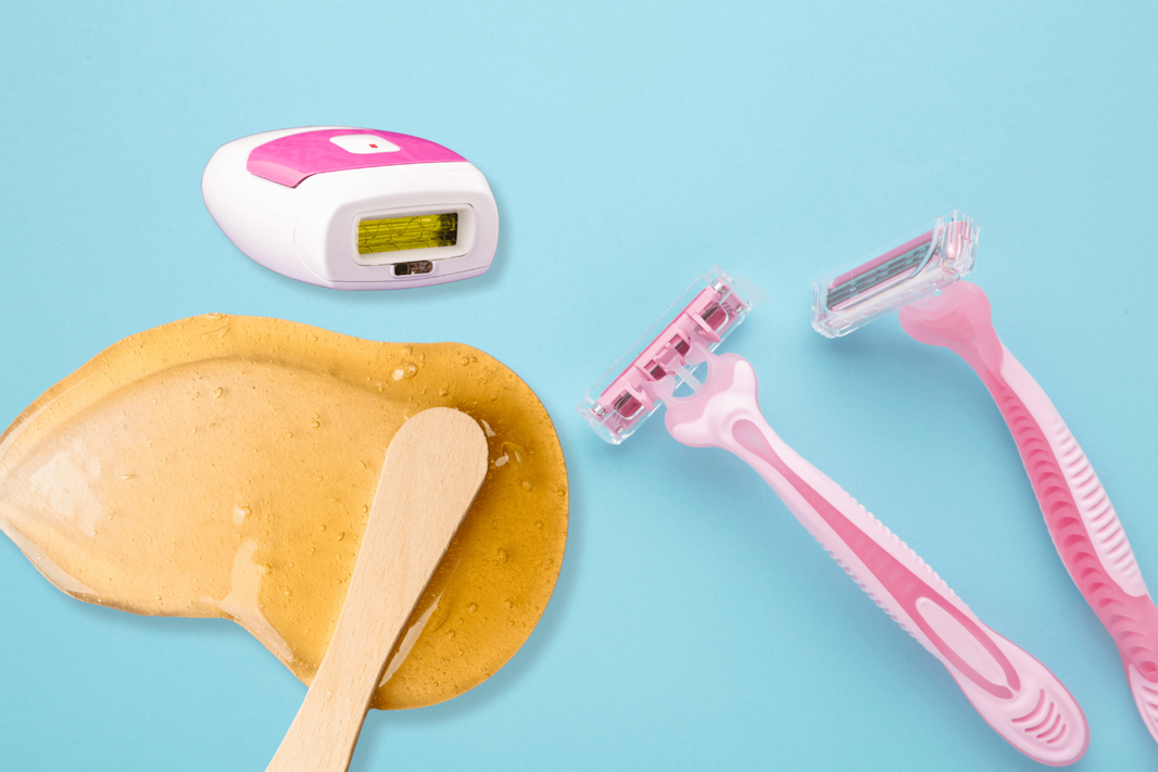 Variety of hair removal tools including an IPL device, razors, and waxing supplies