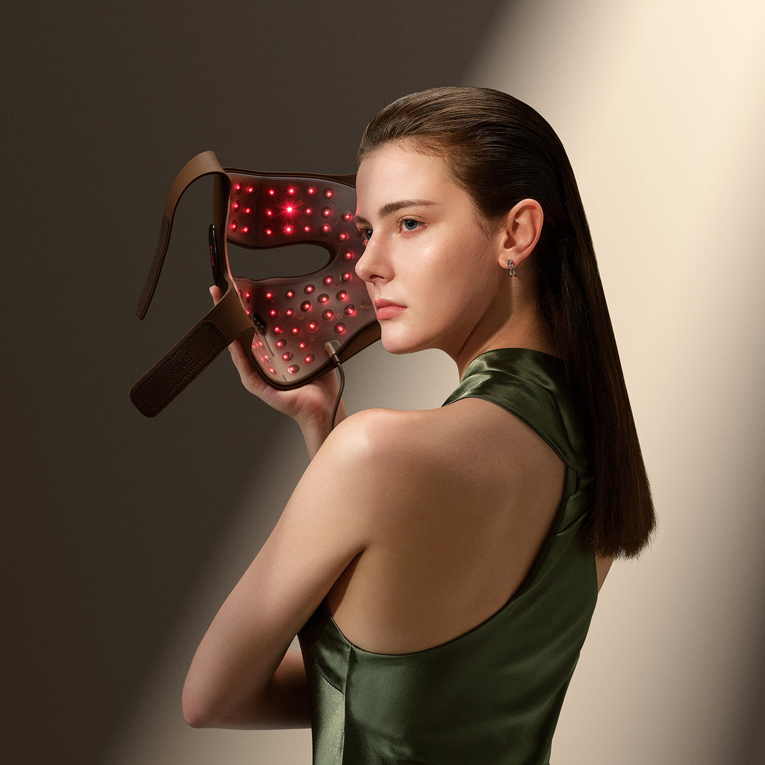 JOVS 4D Laser Light Therapy Mask Woman using JOVS 4D laser light therapy mask for facial rejuvenation, featuring red lights for skincare.