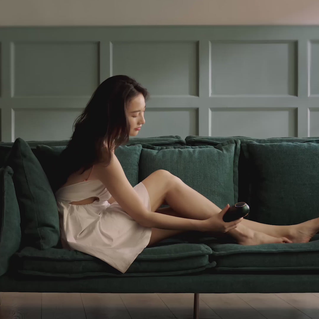 Elegant Woman Comfortably Using JOVS Mini Emerald Wireless IPL Hair Removal Device on Legs at Home