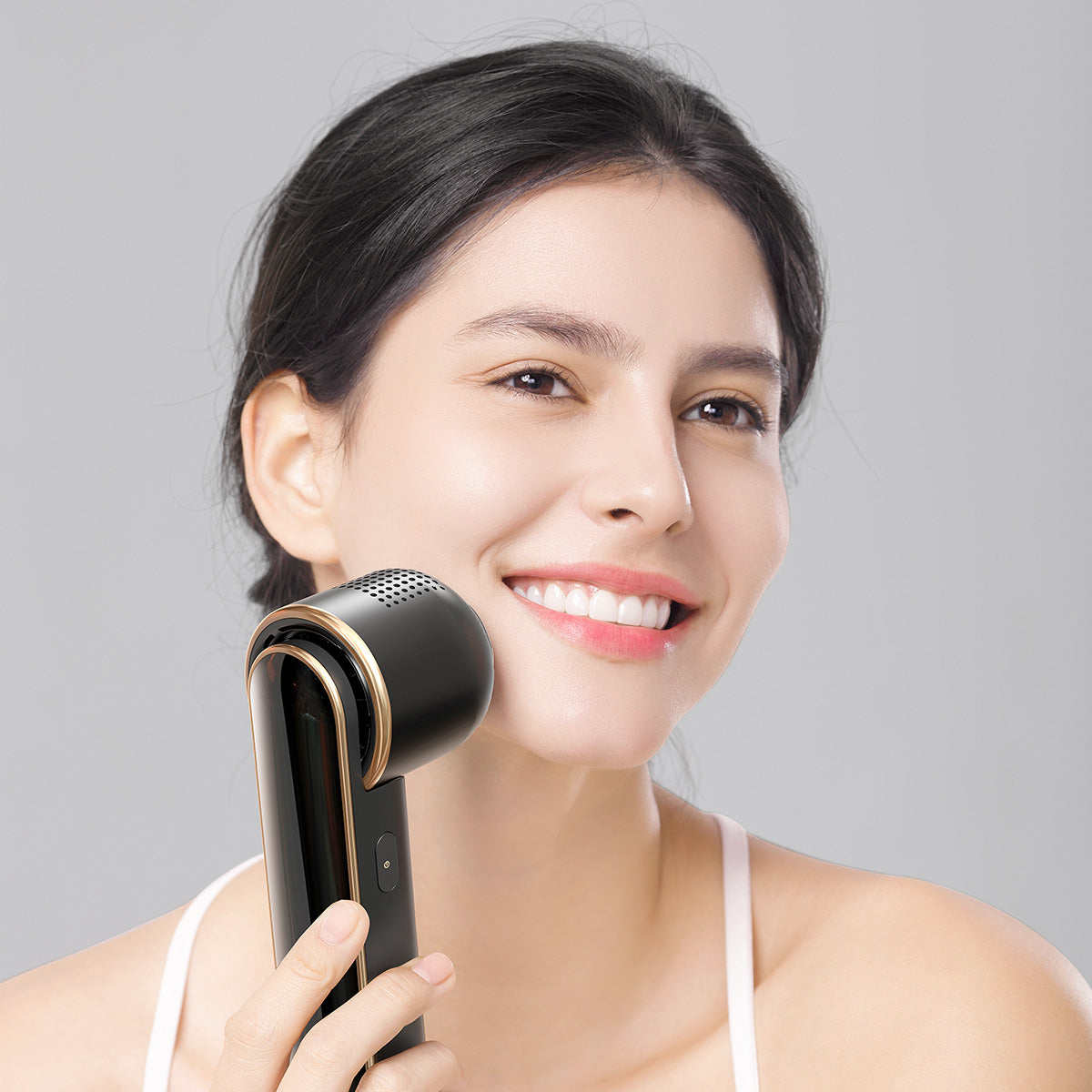 Woman smiling while using the JOVS Blacken DPL Photorejuvenation Device for a radiant and youthful complexion.